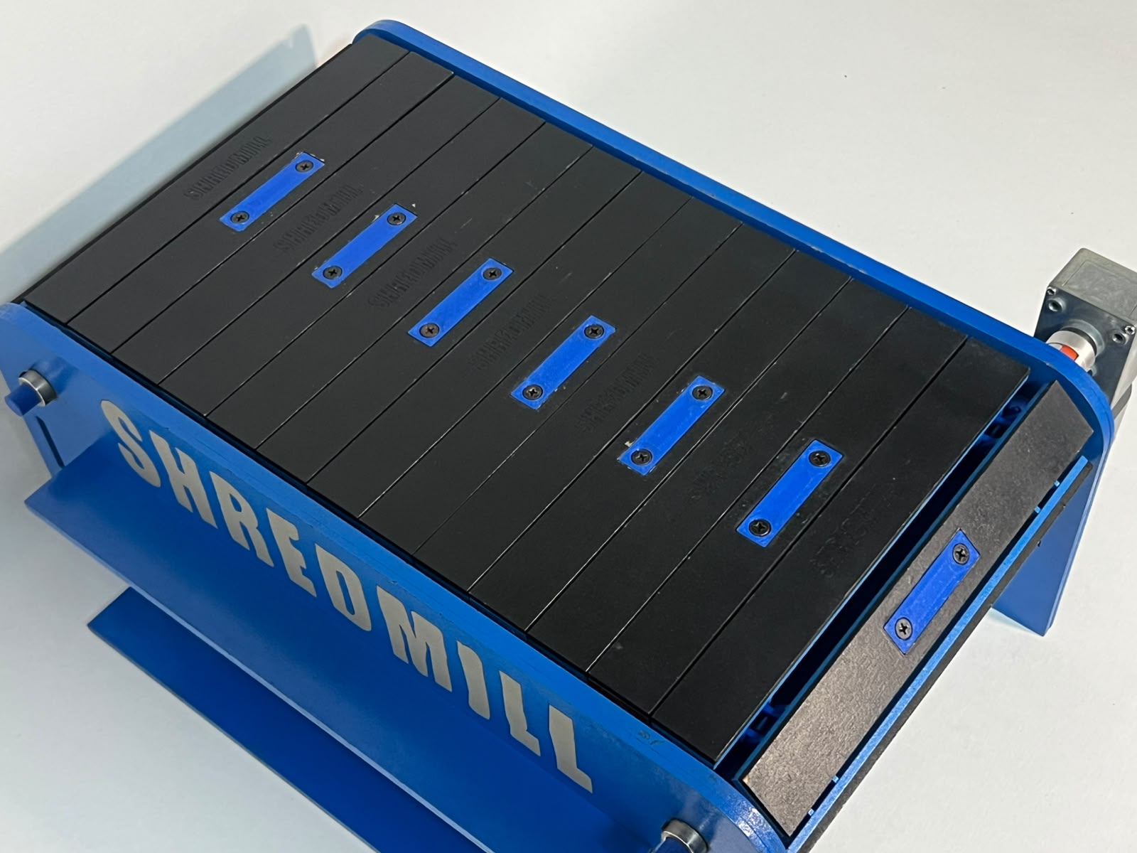 Overhead view of the black segmented surface on the blue Shredmill base